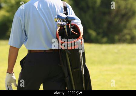 Vista in sezione intermedia di un uomo che porta una borsa da golf Foto Stock