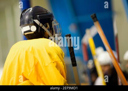 Vista posteriore di un giocatore di hockey su ghiaccio che indossa un casco Foto Stock