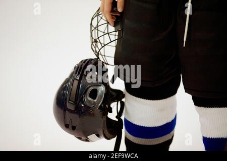 Vista in sezione intermedia di un giocatore di hockey su ghiaccio che tiene un casco Foto Stock