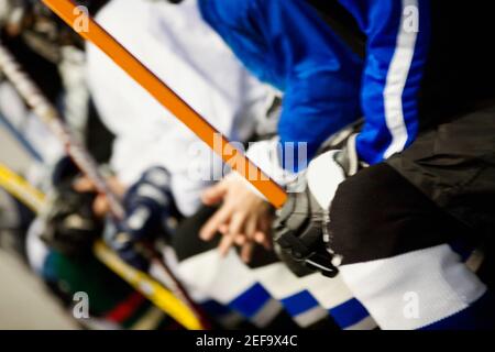 Vista in sezione intermedia di un gruppo di giocatori di hockey su ghiaccio con bastoncini da hockey su ghiaccio Foto Stock