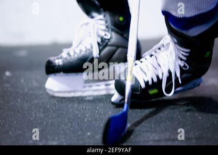 Vista in sezione bassa di un giocatore di hockey su ghiaccio che gioca su ghiaccio hockey Foto Stock