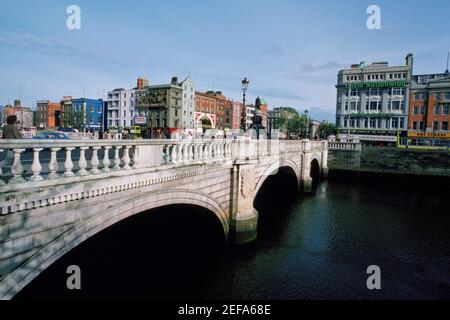 Corride su un fiume, OÅ½Connell Street Bridge, fiume Liffey, Dublino, Repubblica d'Irlanda Foto Stock
