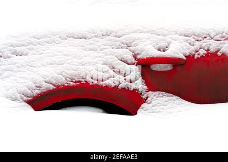 Frammento di un'auto rossa sepolta nella neve dopo un tempesta di neve dura in inverno Foto Stock