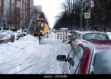 Mosca, Russia-14 febbraio 2021.speciali attrezzature per la rimozione della neve pulisce una strada trafficata di Mosca di neve in inverno innevato Foto Stock