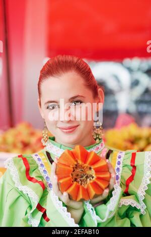 Ritratto di una giovane donna che tiene una papaia Foto Stock