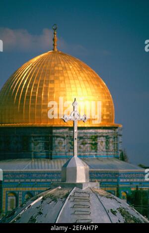 Croce sulla cupola di una chiesa con una moschea sullo sfondo, cupola della roccia, Gerusalemme, Israele Foto Stock