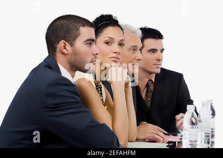 Tre uomini d'affari e una donna d'affari ad una riunione in un sala conferenze Foto Stock