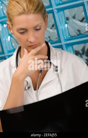 Medico femminile che esamina un rapporto X Ray Foto Stock