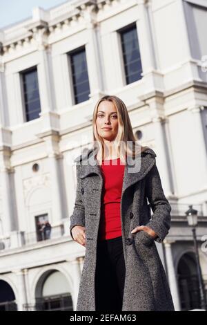 Ritratto di una giovane donna che si trova di fronte a un edificio Foto Stock