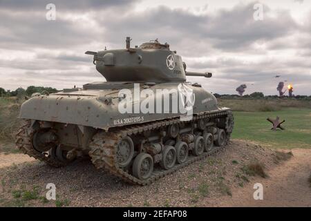 SAINTE-MARIE-DU-MONT, FRANCIA - 22 agosto 2018: M4 Sherman carro armato delle truppe alleate contro due bombardieri tedeschi della seconda guerra mondiale sulla costa della Normandia su una nuvolosa Foto Stock