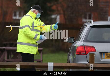 Un lavoratore di prova e traccia nel parcheggio di Bramley Inn a Bramley, vicino Basingstoke, Hampshire parla ad un driver ad un programma di test di pompaggio con residenti locali, dopo che un caso della variante sudafricana di Covid-19 è stato identificato nel villaggio. Data immagine: Mercoledì 17 febbraio 2021. Foto Stock