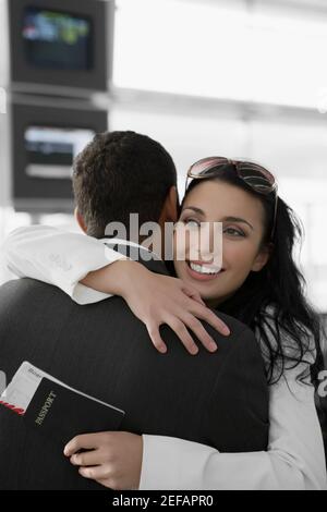 Close up di una donna d'affari che abbracciava un uomo d'affari in un aeroporto Foto Stock