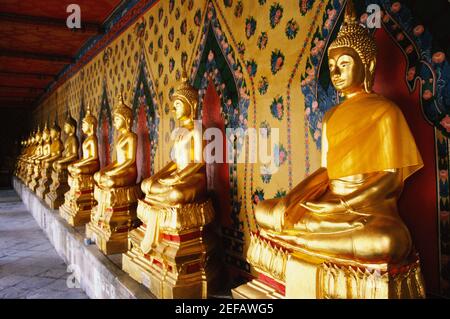 Fila di statue di Buddha in un tempio, Wat Arun, Bangkok, Thailandia Foto Stock