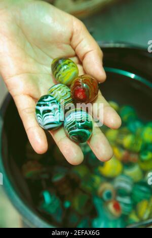 Primo piano di una mano personÅ½s che tiene marmi Foto Stock