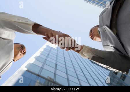 Basso angolo vista di due imprenditrici stringono le mani Foto Stock