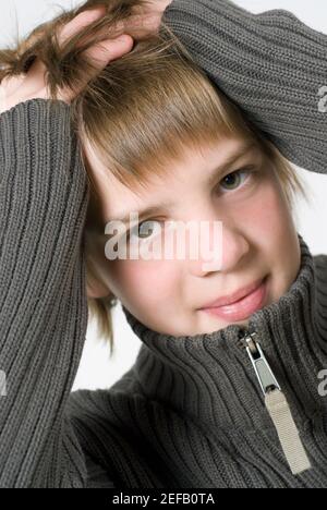 Primo piano di un ragazzo con la testa nelle mani Foto Stock