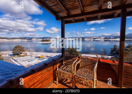 Una panchina con una bella vista lago circondato da Rhodope Montagne sulla diga del lago Batak in Bulgaria Foto Stock