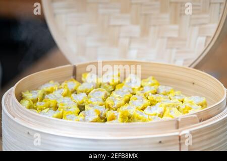 Dim SIM (Kanom jeeb) i gnocchi cinesi al vapore su foglia di banana in bambu vimini piatto per antipasto di seminario. Foto Stock