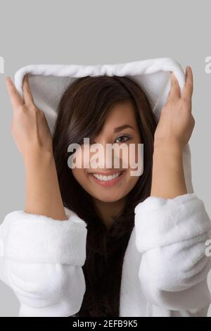 Ritratto di una giovane donna che indossa un accappatoio e sorridente Foto Stock