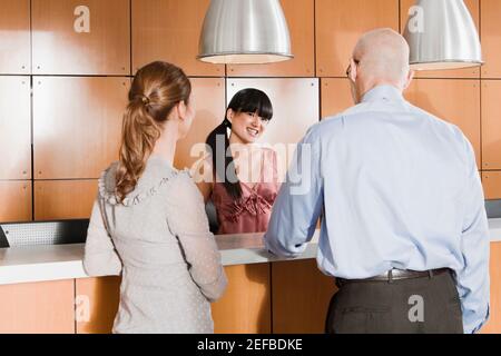 Vista posteriore dei dirigenti aziendali che si trovano alla reception Foto Stock