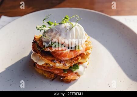 Stack di hash brown con salmone e uovo in camicia sulla parte superiore. Foto Stock