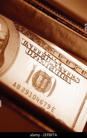 Primo piano estremo di una fattura da cento dollari all'interno del portafoglio Foto Stock