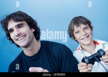 Primo piano di un ragazzo e di suo padre che giocano un videogioco Foto Stock