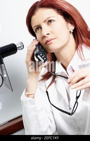 Primo piano di una dottoressa che parla con un telefono cordless Foto Stock