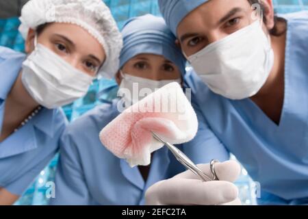 Due chirurghi femminili e un chirurgo maschile in un operatorio camera Foto Stock