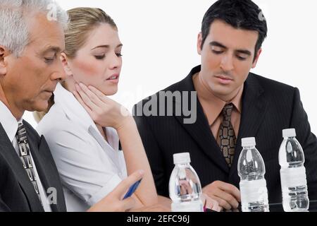 Due uomini d'affari e una donna d'affari in una riunione in un sala conferenze Foto Stock