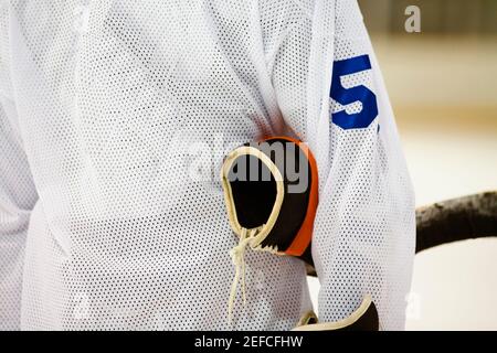 Vista in sezione intermedia di un giocatore di hockey su ghiaccio con un guanto sotto il braccio Foto Stock