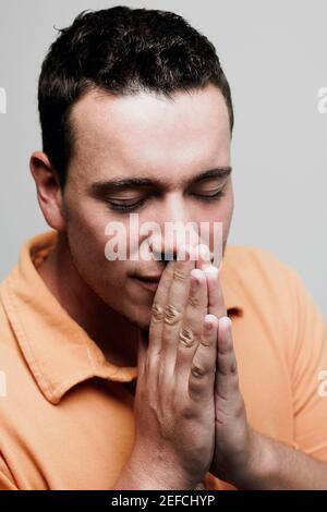 Primo piano di un uomo medio adulto in posizione di preghiera Foto Stock