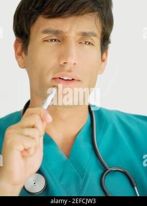 Primo piano di un giovane medico maschile che pensa Foto Stock