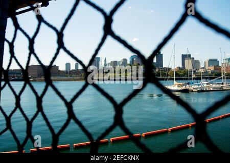 Barche a vela in un fiume visto attraverso una recinzione catena-collegamento, Boston, Massachusetts, Stati Uniti Foto Stock