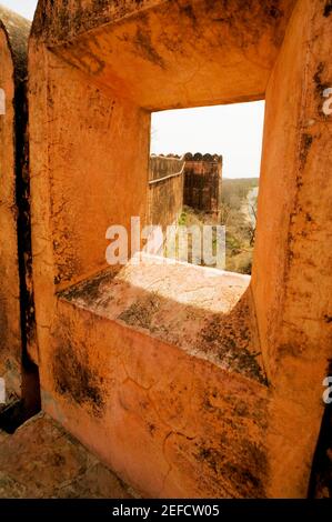 Muro di un forte visto da una finestra, forte di Jaigarh, Jaipur, Rajasthan, India Foto Stock