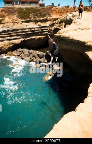 Vista ad alto angolo di due persone su una barriera corallina che si affaccia su un'insenatura, Coronado Reef, San Diego, California, USA Foto Stock