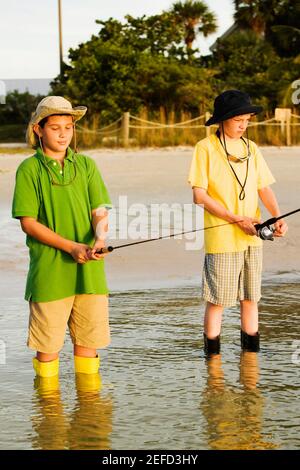 Due fratelli che pescano in un lago Foto Stock