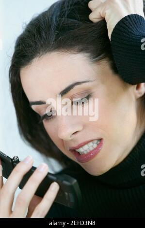 Primo piano di una giovane donna che guarda arrabbiato a un cellulare telefono Foto Stock