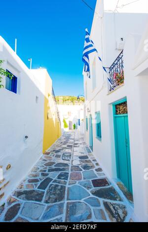 Strada stretta con pavimento in pietra e case rustiche tradizionali sull'isola di Paros, Grecia Foto Stock