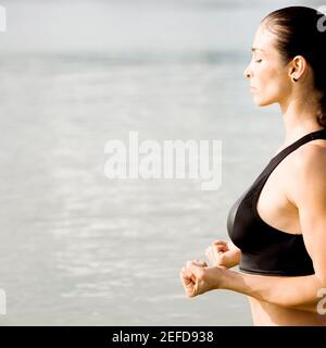 Profilo laterale di una giovane donna a praticare arti marziali Foto Stock