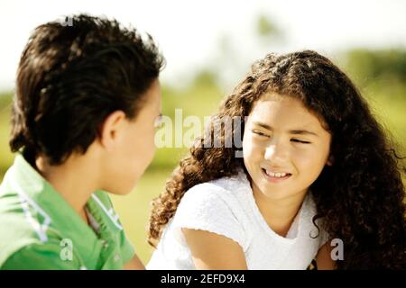 Profilo laterale di un fratello e di sua sorella che parlano Foto Stock