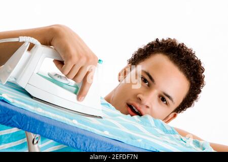 Ritratto di un giovane che stira la camicia Foto Stock