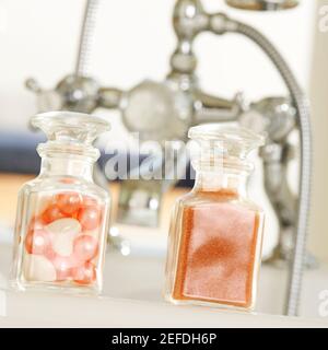 Primo piano di polvere di sapone e perle da bagno in bottiglie di vetro Foto Stock