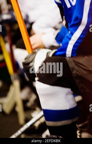 Vista in sezione intermedia di un giocatore di hockey su ghiaccio che tiene un bastone per hockey su ghiaccio Foto Stock