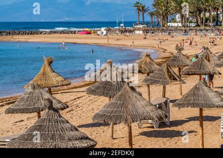 Spiaggia di Playa del Camison. Si tratta di una piccola spiaggia con ombrelloni paglia in Tenerife isola, Canarie, Spagna, fuoco selezionato Foto Stock