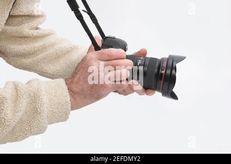 Un uomo che tiene una fotocamera reflex digitale Canon Foto Stock