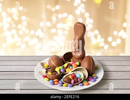 coniglietto al cioccolato, uova e caramelle sopra le luci Foto Stock