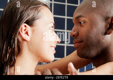 Primo piano di una giovane coppia che si affaccia l'una con l'altra nel bagno Foto Stock