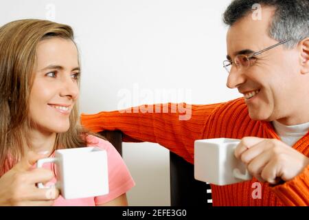 Primo piano di una coppia di metà adulti che tiene due tazze di caffè Foto Stock