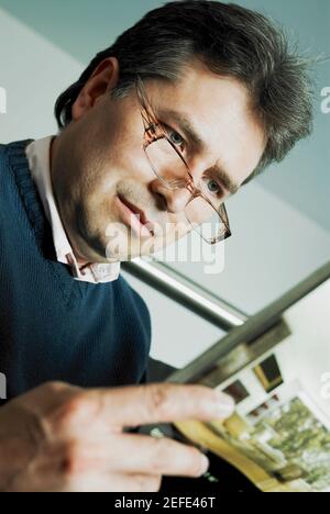 Primo piano di un uomo maturo che legge una rivista Foto Stock